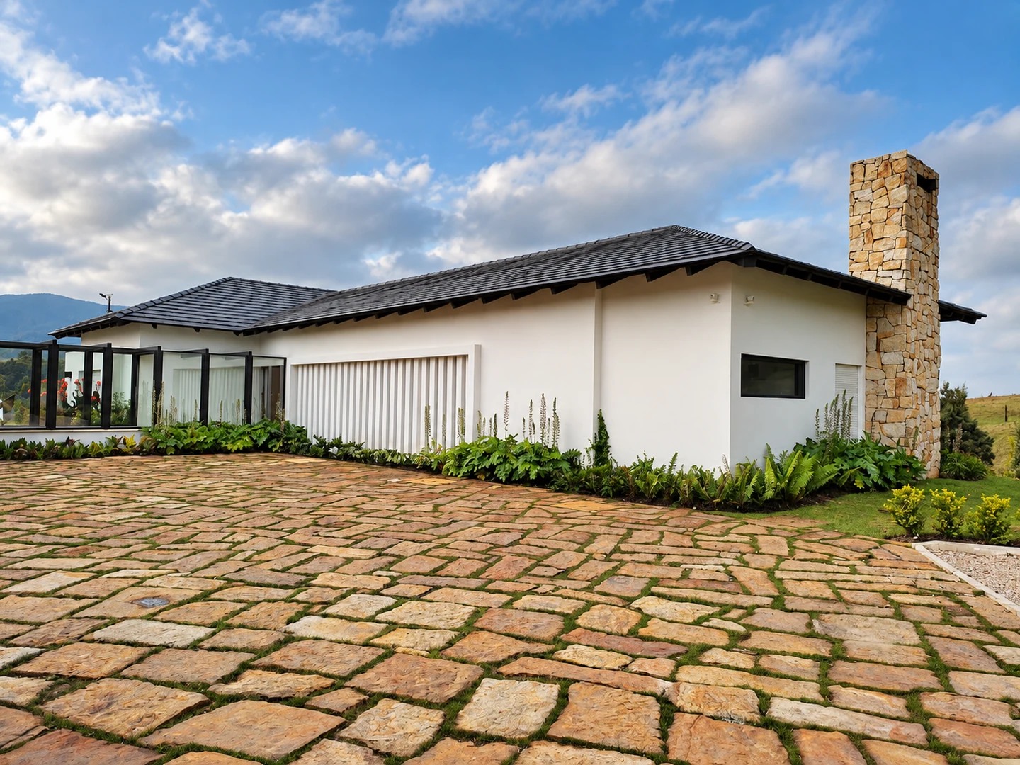 Vista exterior de Casa Gerfor, con cubierta inclinada, chimenea de piedra y acceso adoquinado. Versión retocada con IA.